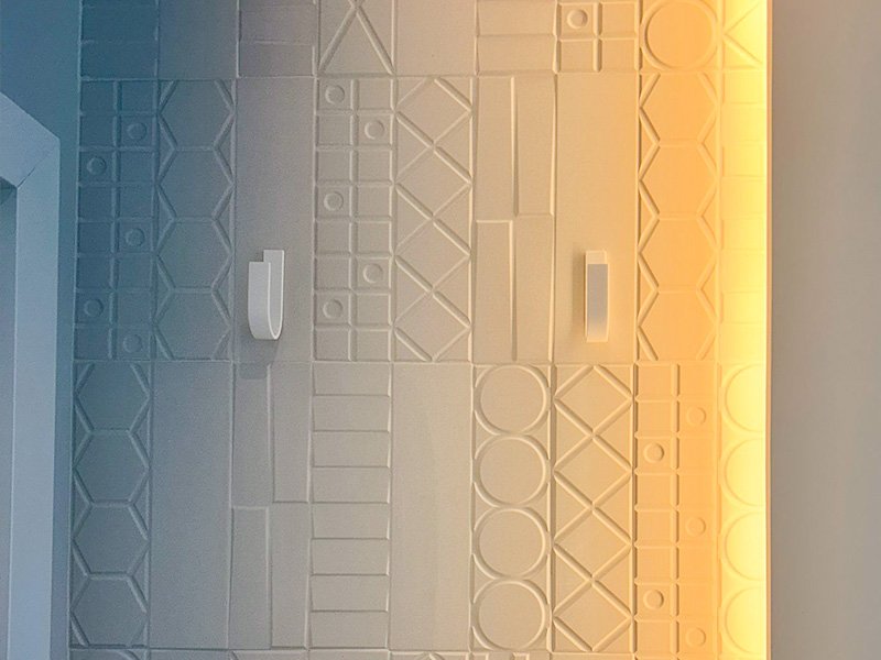 Pared de Corian con percheros de Solid Creaciones instalados, foto real de clienta