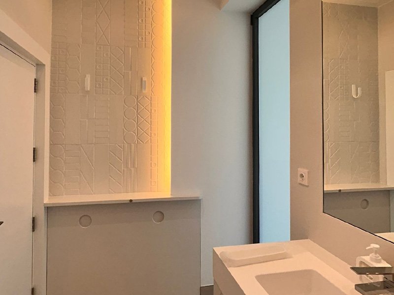 Bano reformado con pared de Corian y mueble de bano de Solid Creaciones, foto real de clienta