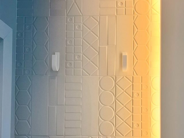Pared de Corian con percheros de Solid Creaciones instalados, foto real de clienta